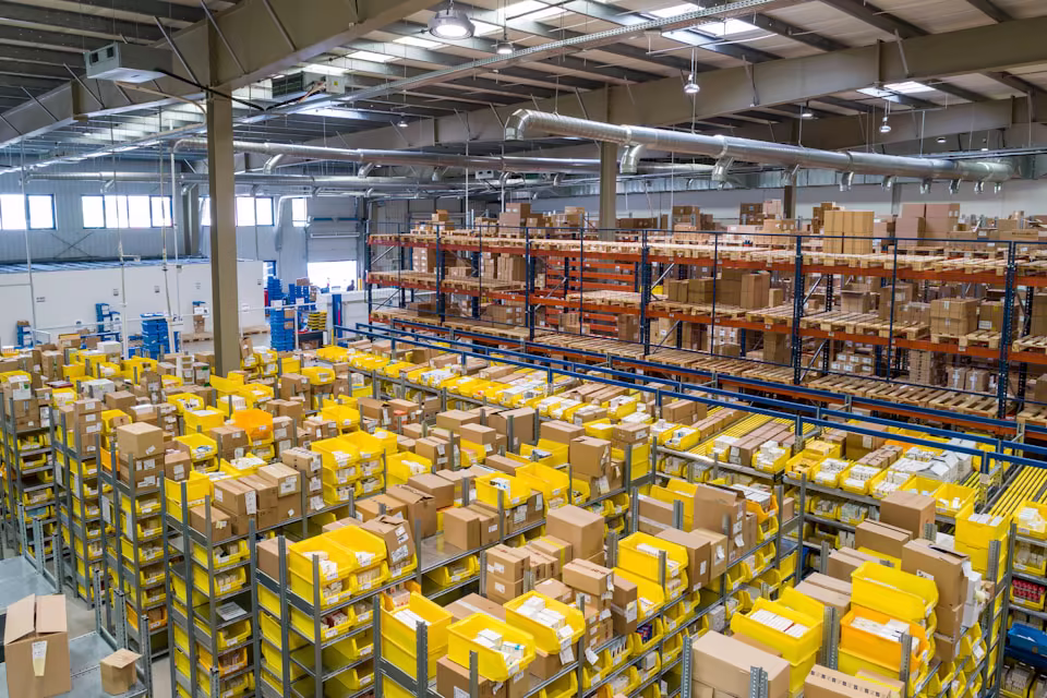 Warehouse aisle with pallets and shelving, distribution operation.